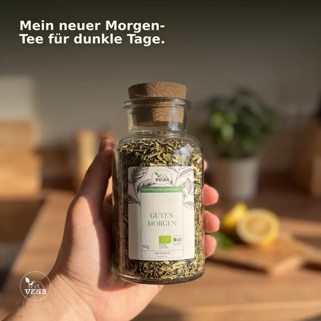 Anzeige für Teaveda: Hand hält ein Teeglas am Morgen — „Mein neuer Morgen-Tee für dunkle Tage.“